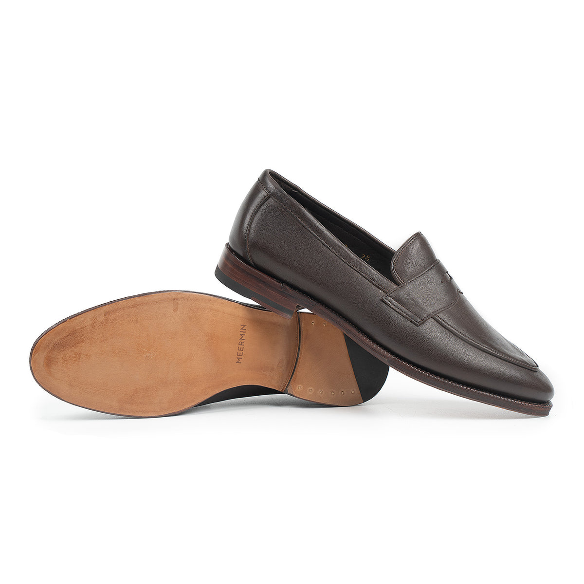 Meermin brown softcalf penny loafer pair, one shoe upright showing the upper, the other flipped to reveal the leather sole