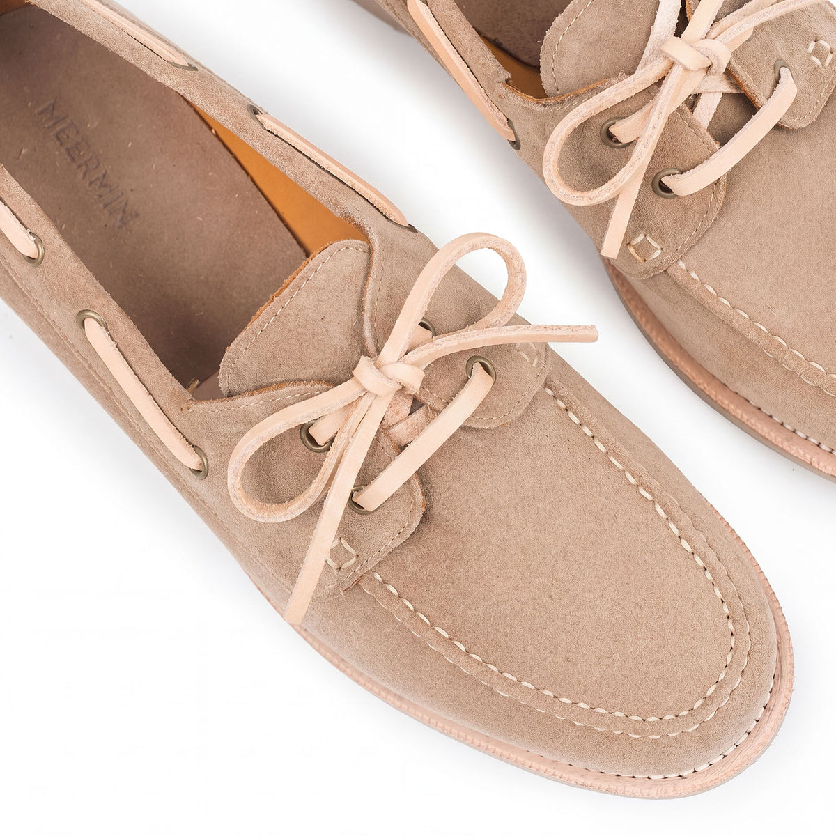 Meermin taupe suede deck shoes, close-up on veg-tan leather laces and brass eyelets, showing moc-toe stitching and vamp detail