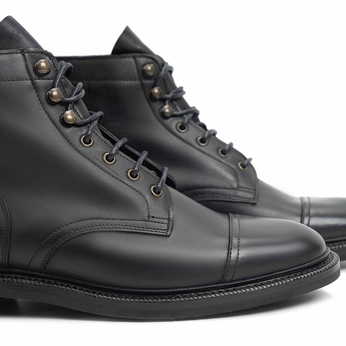 Meermin black waxy calf cap-toe boots, close-up on toe caps and lace eyelets, showing the NEGON last's rounded, wider toe shape