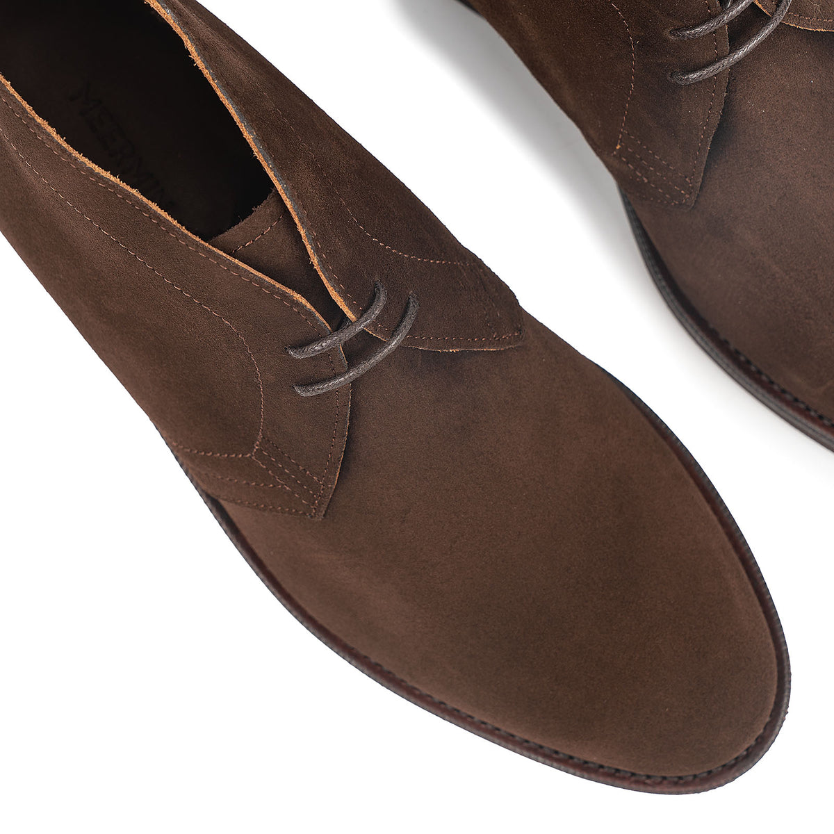 Meermin brown Superbuck suede chukka boots, close-up top view showing lace eyelets, toe shape, and welted sole edge