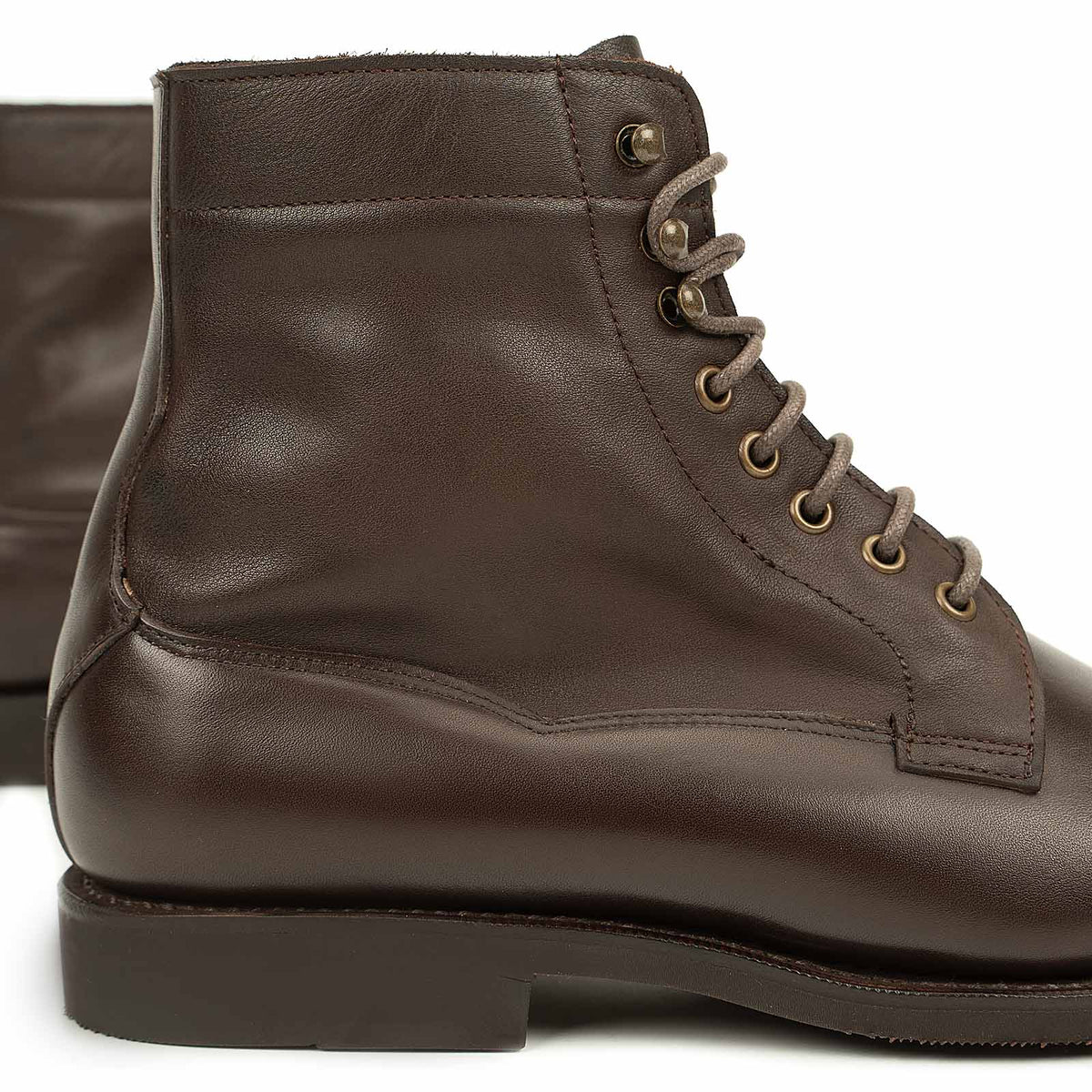 Meermin brown softcalf boot, close-up on heel and lace eyelets showing bronze hardware and diamond latex rubber sole