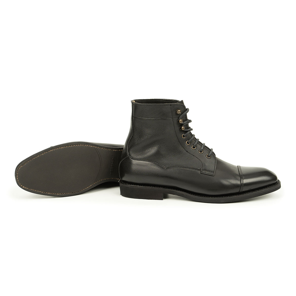 Meermin black cap-toe boot shown upright beside its paired sole turned over, displaying diamond latex rubber sole tread and lace-up softcalf shaft