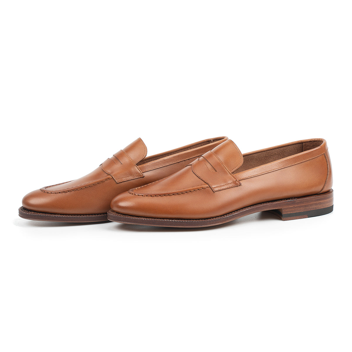 Meermin tan antique calf penny loafers, three-quarter side view showing both shoes with closed-channel leather sole and stacked heel