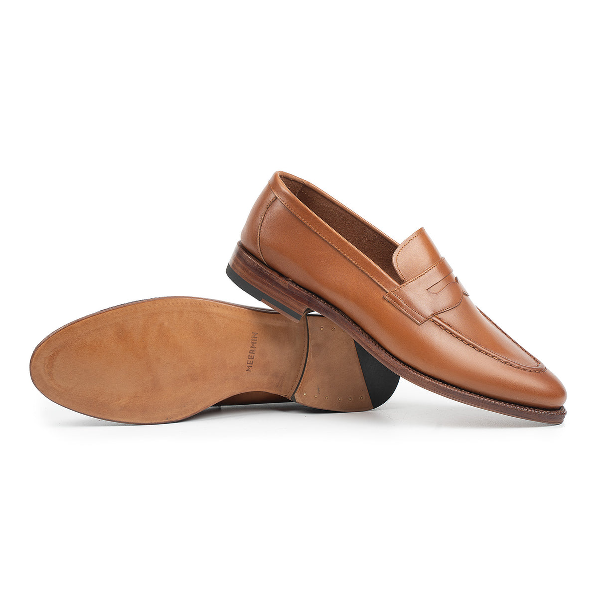 Meermin tan antique calf penny loafers, side profile with one shoe overturned showing leather sole and heel stack