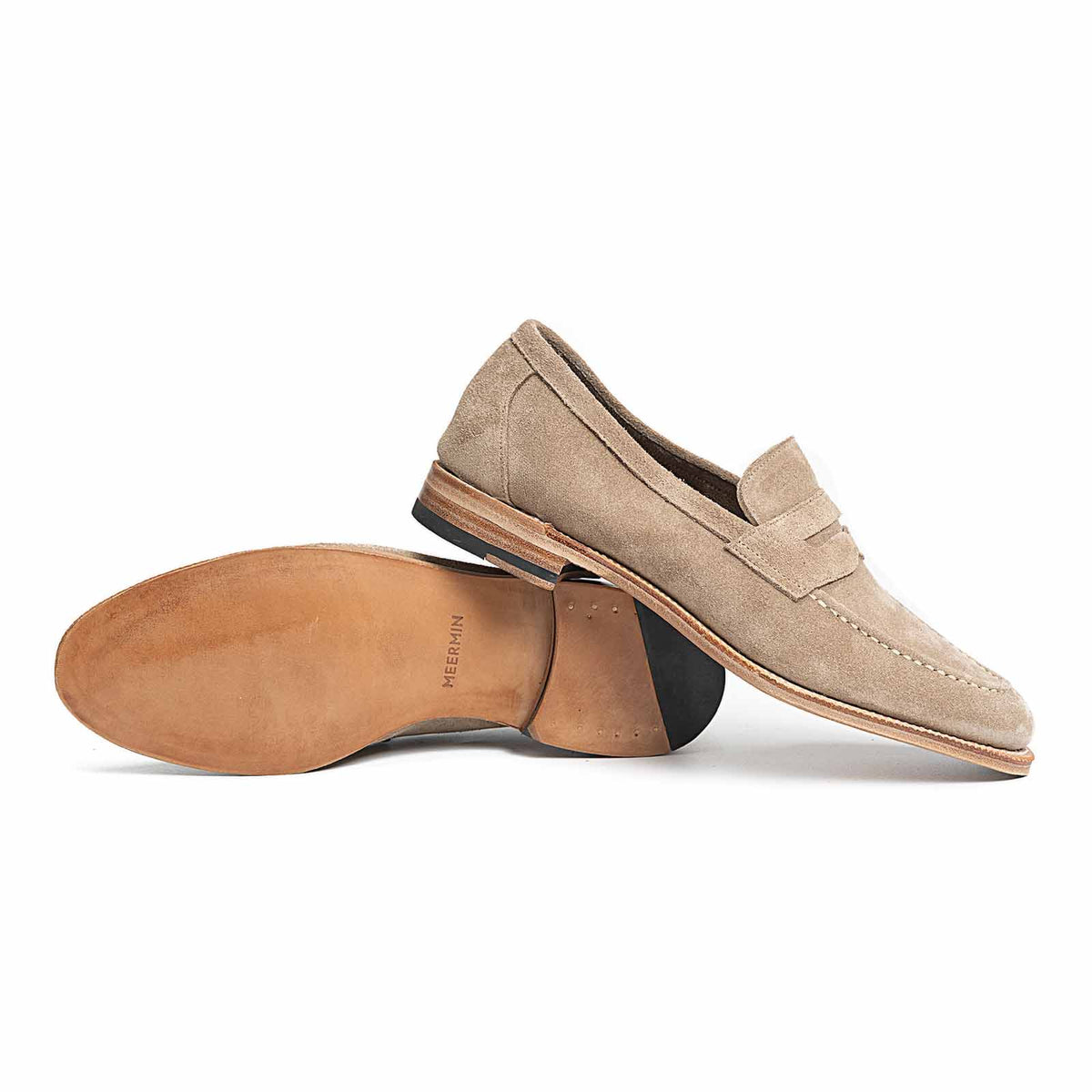 Meermin taupe suede penny loafers, side profile with one shoe flipped to show the closed-channel leather sole