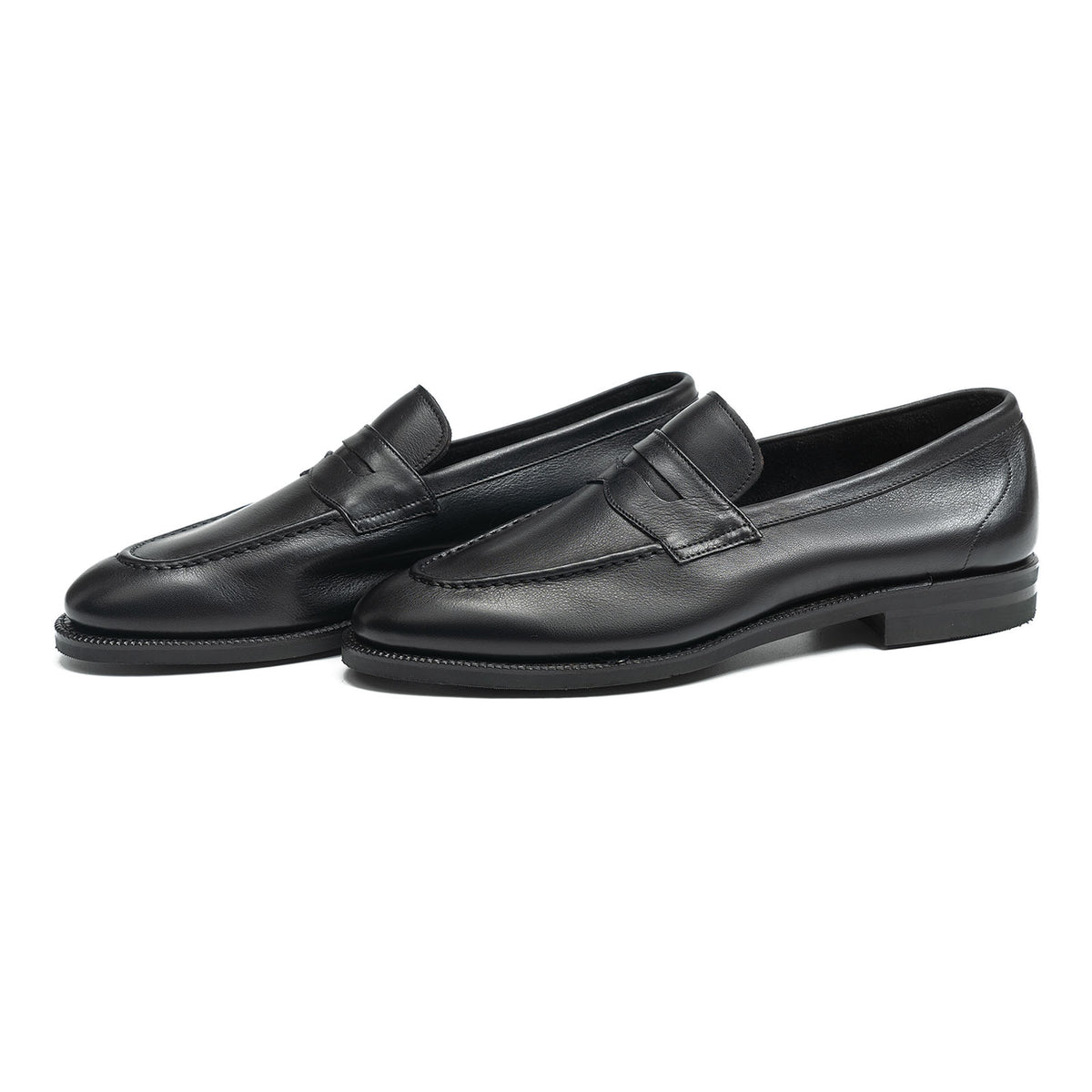 Meermin black softcalf penny loafers, three-quarter side view showing both shoes and city rubber sole detail