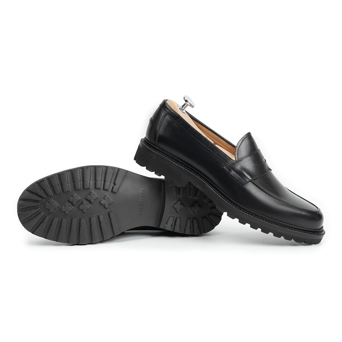 Meermin black boxcalf penny loafers, side profile with one shoe upright and one on its side showing cleated rubber sole tread