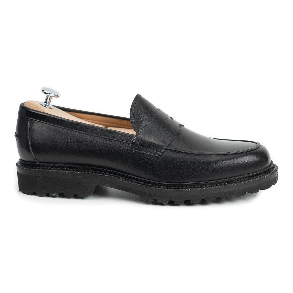 Meermin black boxcalf penny loafer, side profile on shoe tree, showing apron stitching, cleated flex Goodyear welted sole