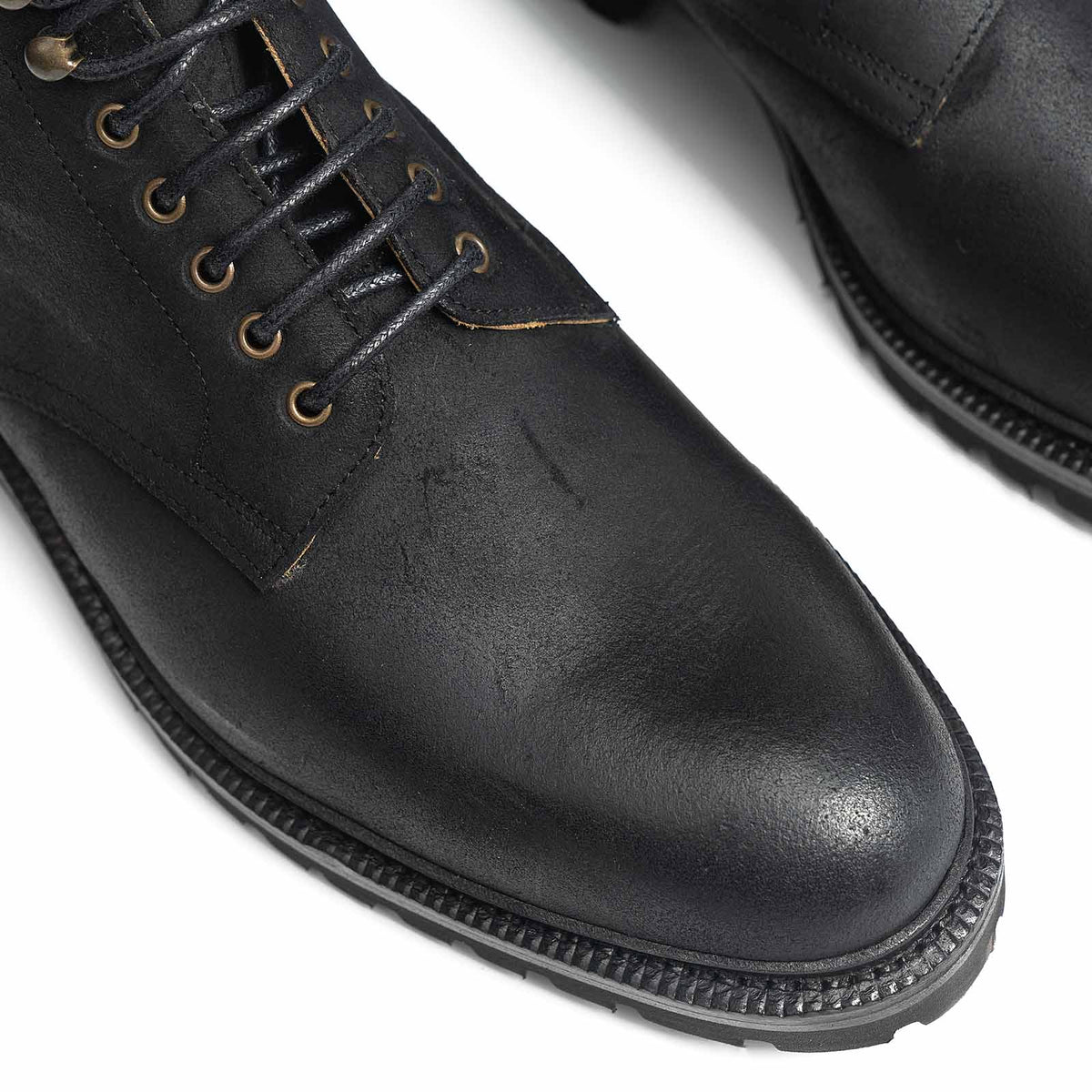 Meermin black waxy commander Service boots, close-up top view of toe caps, lacing eyelets, and cleated rubber soles