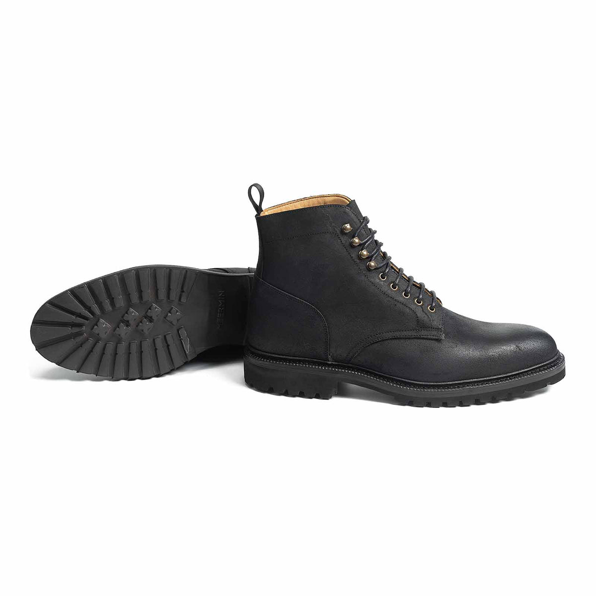 Meermin waxy commander boot in black, paired view showing side profile and cleated rubber sole tread of the other boot