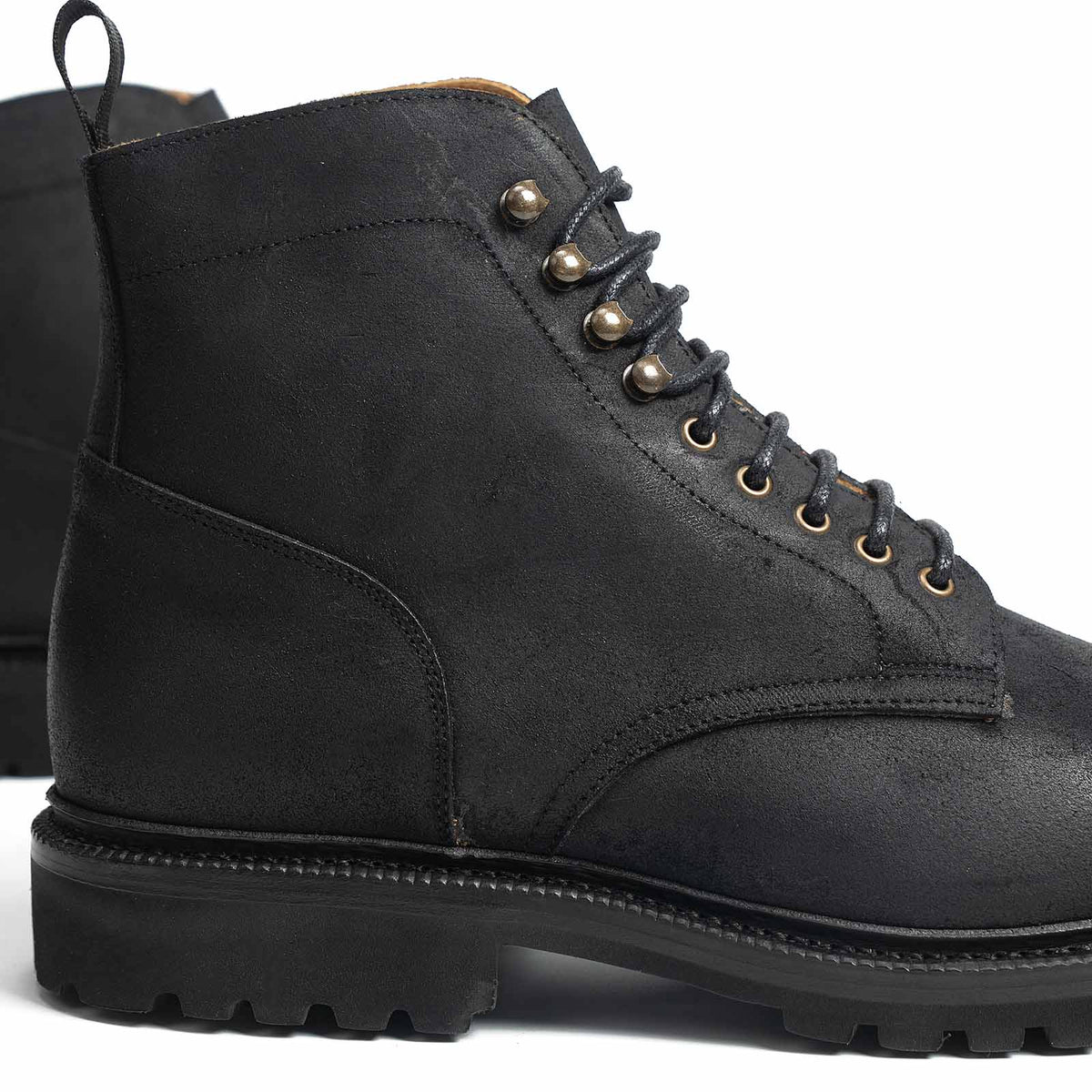 Meermin black waxy commander Service boot, close-up on lace eyelets, heel counter, and cleated rubber sole