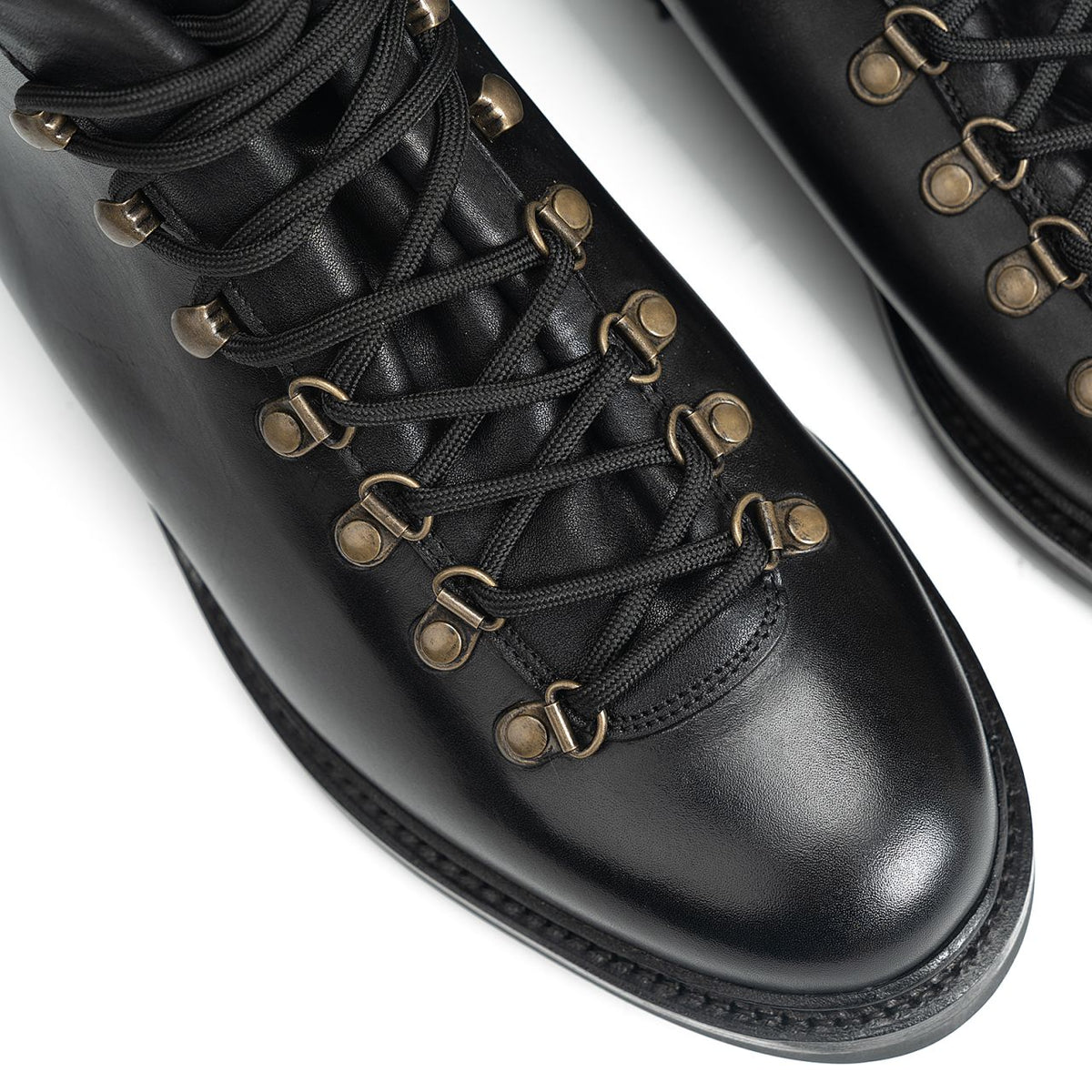 Meermin black calf hiking boots, close-up on toe cap and antique brass hook-and-eye lacing detail