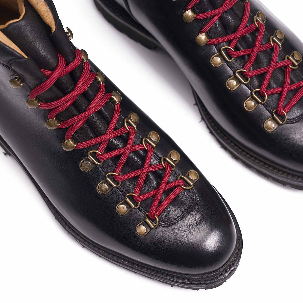 Meermin black calf hiking boots, close-up on toe caps showing burgundy laces crossed through brass D-ring eyelets