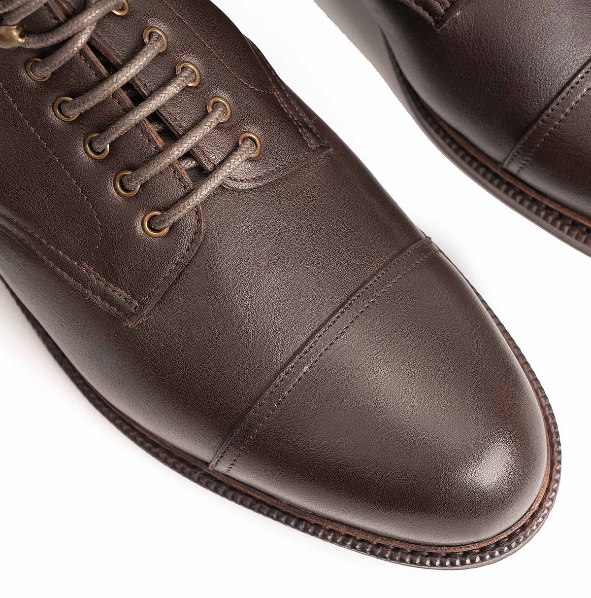 Meermin brown softcalf leather boots, close-up on cap-toe stitching, lace eyelets, and studded rubber sole edge