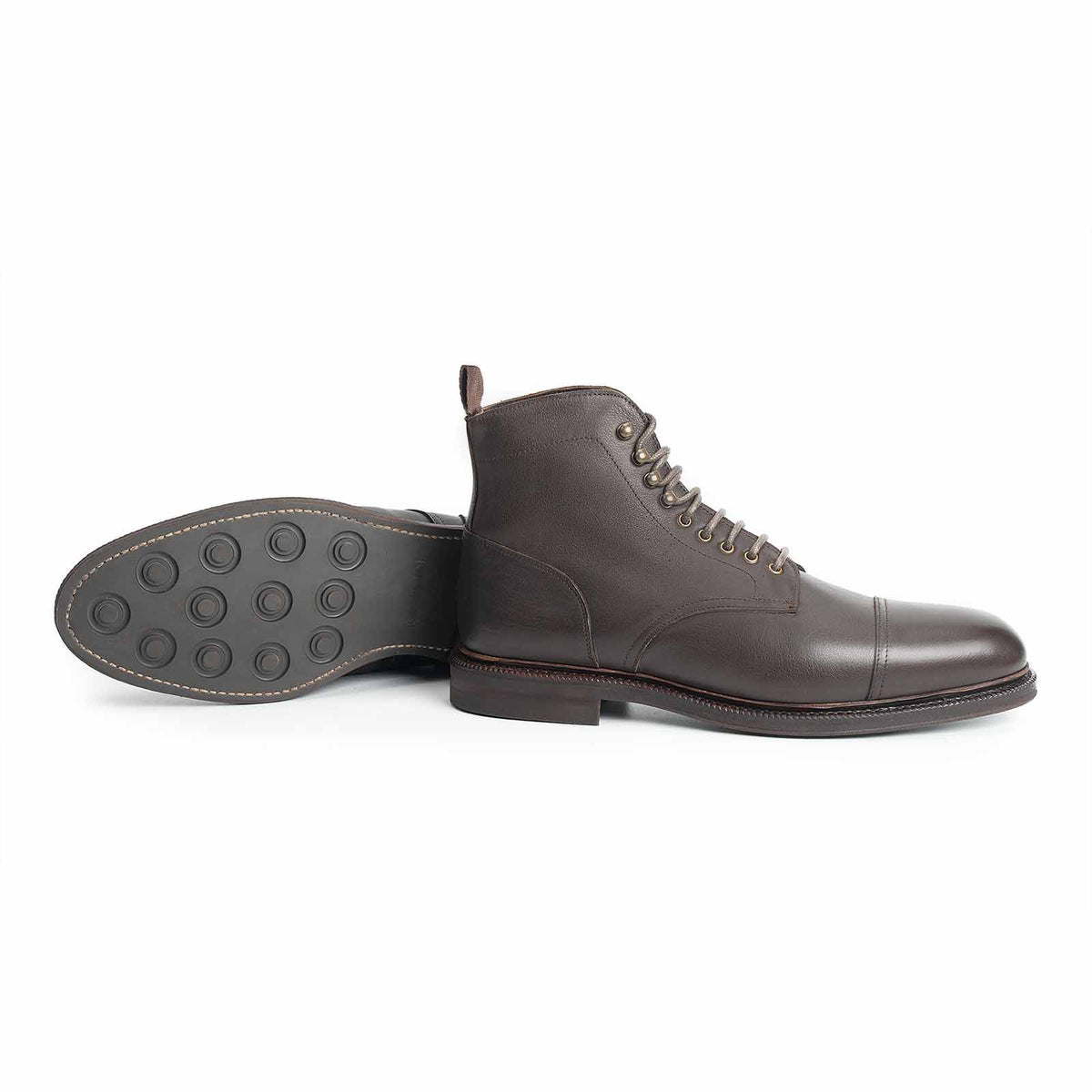Meermin brown softcalf cap-toe boot, side profile with paired sole facing up showing studded rubber tread detail